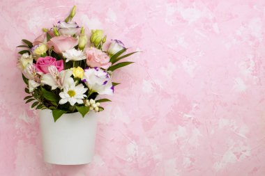 Gül buketi düz yatıyordu papatyalar lisianthus kasımpatılar, açılmamış tomurcuklar beyaz bir karton kutunun içinde pembe beton bir arka planda çizgiler ve lekeler