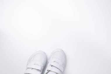İki beyaz koşu ayakkabısının üst görünümü kısmen altta, beyaz arkaplanda izole edilmiş metin için boş alanı var