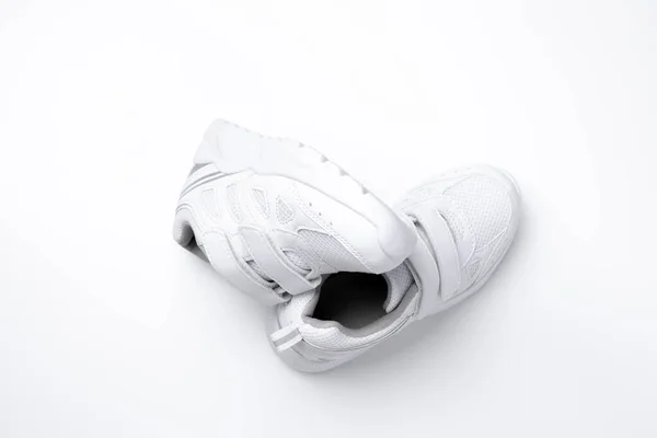 Bovenaanzicht set witte unisex sneakers symbool van gezonde sportgewoonten en gezondheid geïsoleerd op een witte achtergrond — Stockfoto