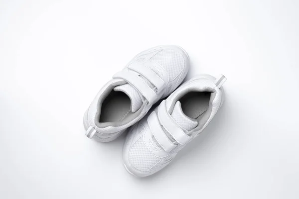 Vista superior dos zapatillas adolescentes blancas con velcro situado en diagonal aislado sobre un fondo blanco —  Fotos de Stock