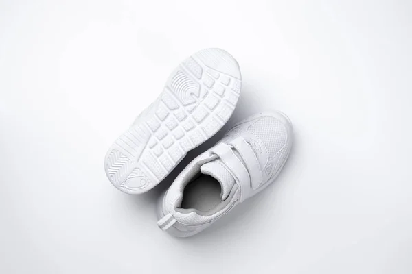 Macro vista dall'alto Due scarpe da corsa unisex bianche, una scarpa da corsa si trova suola isolata su sfondo bianco — Foto Stock