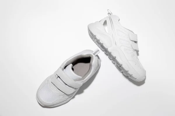 Üst görünüm beyaz unisex koşu ayakkabıları cırt cırtlı bağlayıcılar kolay ayakkabılar için sert gölgeler beyaz arka planda izole — Stok fotoğraf