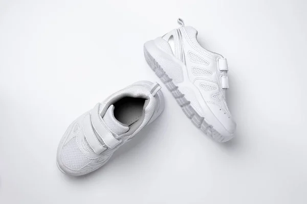 Top view από δύο λευκά παιδικά sneakers με velcro συνδετήρες για εύκολο παπούτσι που απομονώνονται σε λευκό φόντο — Φωτογραφία Αρχείου