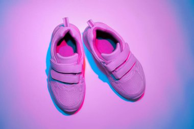 beyaz arka planda iki beyaz çocuk ayakkabısı ve renkli mavi ışık filtreli cırt cırtlı bağcıklar vardı.