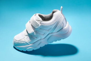 Makro kenarlı bir manzara. Mavi arka planda cırt cırtlı bağcıklı uçan beyaz bir çocuk.