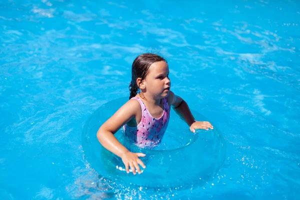 Islak beyaz kız, güneşli bir günde otelde havuzda zıplayıp eğleniyor. — Stok fotoğraf