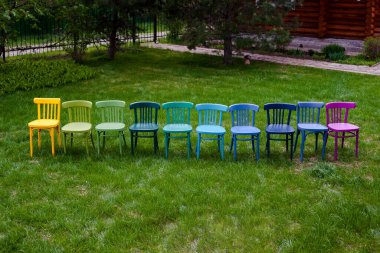 Üst üste bir sıra renkli Viyana sandalyesi, eski mobilyaları boyamak için bir hobi ve alışılmadık bir köy evi tasarımı.