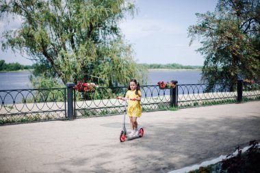 Küçük bir aile gezisinde yaz aylarında motosikletli uzun boylu bir kız.