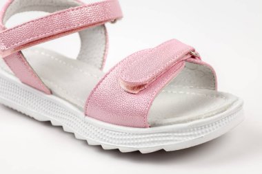 Pembe izole sandaletler. Beyaz tabanlı pembe sandaletler ve beyaz arka planda izole edilmiş cırt cırtlı bağcıklar. Çocuklar için şık çocuk ayakkabıları.