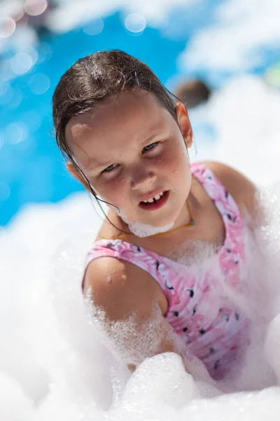 Sahilde sıcak bir yaz günü köpük dolu bir partide beş yaşında bir kızın yakın plan portresi. — Stok fotoğraf