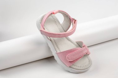 Pembe izole sandaletler. Beyaz tabanlı pembe sandaletler ve beyaz arka planda izole edilmiş cırt cırtlı bağcıklar. Çocuklar için şık çocuk ayakkabıları.