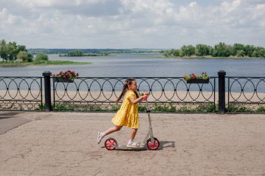 Bir çocuk hızla körfez boyunca motosiklete biniyor, aile hafta sonlarında eğleniyor, çocuk aktiviteleri yapıyor.
