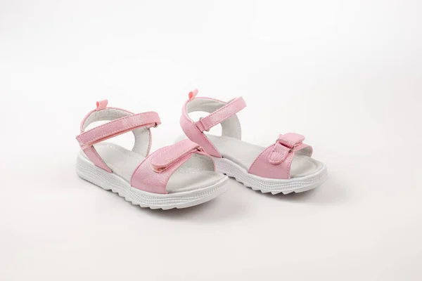 Sandálias infantis rosa feitas de couro brilhante com fechos de velcro, solas brancas planas isoladas em um fundo branco. Um par de sandálias infantis na moda para um passeio confortável. — Fotografia de Stock