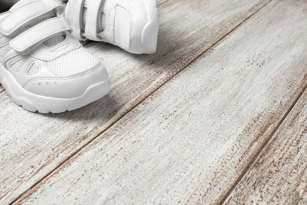 Sneakers in pelle bianca su sfondo chiaro. Coppia di scarpe da ginnastica bianche alla moda per bambini con spazio copia per testo o design — Foto Stock