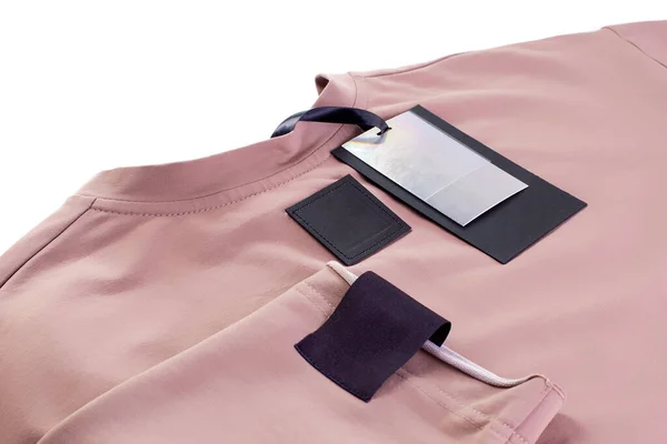 Koldaki marka logosu için kumaş boş siyah yama, izole edilmiş beyaz arka planda bej giysiler üzerinde eko deri etiket ve kağıt etiket — Stok fotoğraf