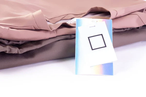 Makro boş metalik parlak yanardöner etiketi ya da bir yığın tişört ya da kapüşonlu kapüşonlu etiketi taklit eder — Stok fotoğraf