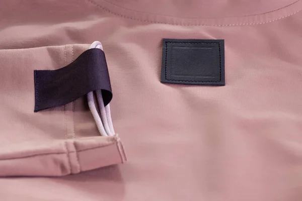 Makro, beyaz kareli kumaş boş siyah yama, kolunda marka logosu ve kahverengi ceketinde siyah eko deri etiket. — Stok fotoğraf