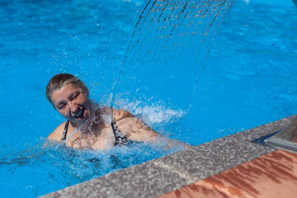 Mujer feliz está descansando en verano en el resort. Persona está disfrutando de vacaciones de verano en el complejo tropical y relajarse en la piscina del centro de spa en la orilla del mar —  Fotos de Stock