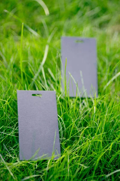 Seitenansicht von zwei schwarzen Preisschildern für Kleidung kreative Gestaltung des Rasens grünes Gras mit Logo-Tag — Stockfoto