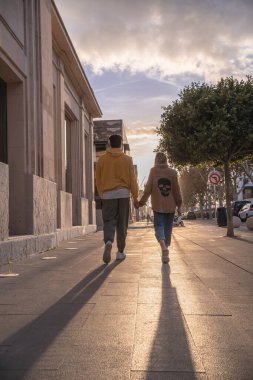 Siyah Afro-Amerikan adam sarı kazak giyiyordu. Sokakta sarışın bir kadınla el ele yürüyordu.