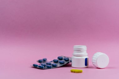 Pembe arka planda ilaç şişesi ve su toplaması.