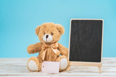 Sevgililer Günü ayısı mavi arka planlı beyaz masada.