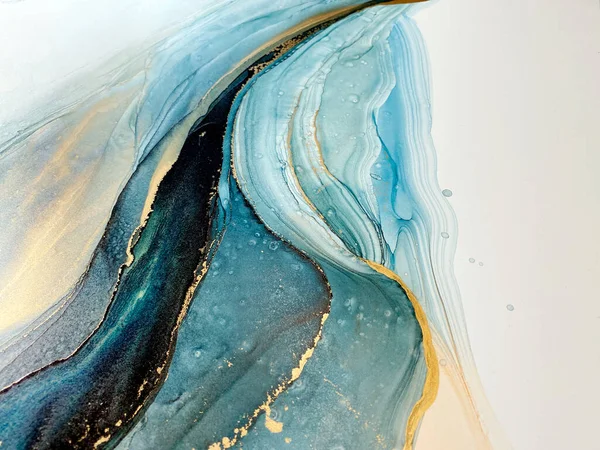 Abstract blue-green background with gold, beautiful smudges and stains made with alcohol ink and metallic pigment. Fragment of art with turquoise texture resembles sea, watercolor or aquarelle.