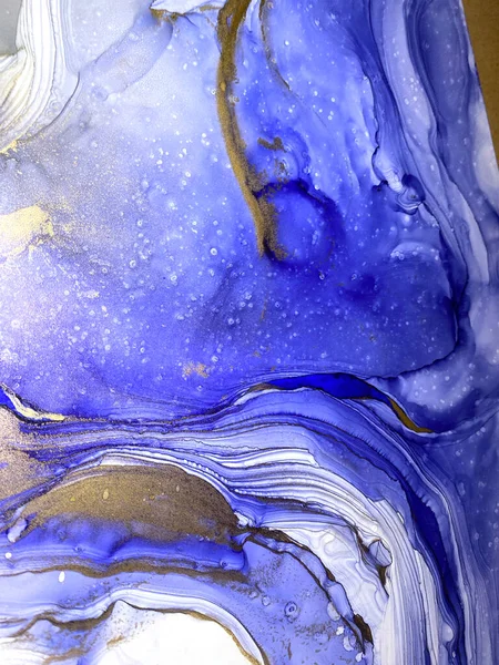 Abstract blue background with beautiful smudges and stains made with alcohol ink and gold pigment. Fluid art with blue texture resembles sea, ocean, watercolor or aquarelle painting.