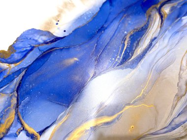 Abstract blue background with gold. Liquid abstraction with beautiful smudges and stains made with alcohol ink and golden paint. Blue fluid texture resembles sea, watercolor or aquarelle.