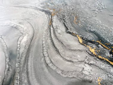 Gri ve altın rengi soyut mavi arka plan. Sıvı fon. Alkol mürekkebi ve altın metalden yapılmış güzel lekeler ve lekeler. Mavi doku taşı, denizi, gökyüzünü, suluboyayı veya akvaryumu andırır..