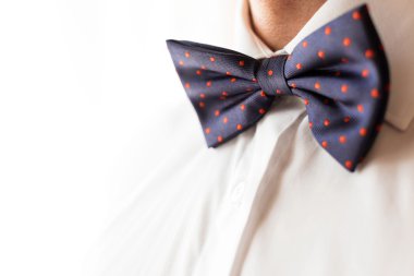 Modaya uygun bir damat bir papyon giyiyor