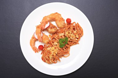 Beyaz tabakta servis edilen domates kremalı spagetti ve kızarmış karides, Tayland-İtalyan tarzı füzyon yemeği. 