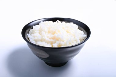 Japanese rice cooked in a black bowl isolated on a white background 