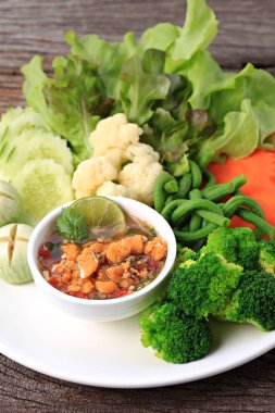 Baharatlı Yengeç Roe Relish Paste ve eski ahşap arka planda taze sebze karışımı. 