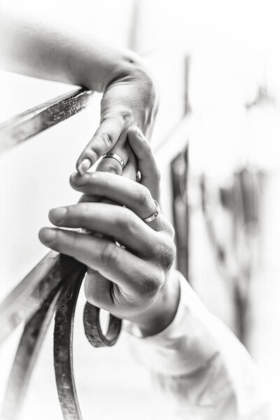 Черно-белая фотография. Закрыть фотографию рук жениха и невесты с обручальными кольцами. 