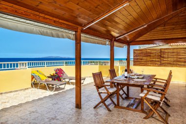 Oturma odası elemanı. Masanın üzerinde ananas şeklinde dekorasyon var. Arka planda dekoratif yastıklı kanepe. 