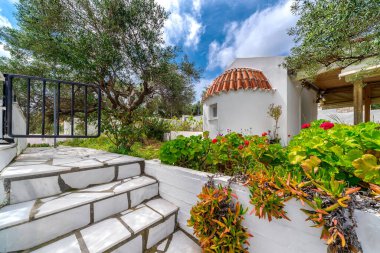 Beyaz mermer basamaklar, bahçedeki küçük, beyaz bir Yunan ortodoks kilisesine çıkıyor..