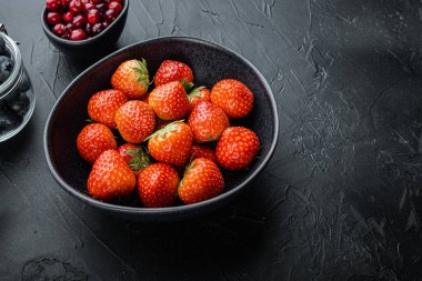 Olgun kırmızı çilek ile metin için boşluk, siyah arkaplan.