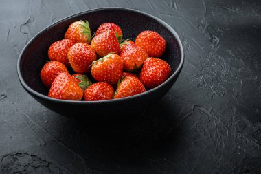 Olgun kırmızı çilek ile metin için boşluk, siyah arkaplan.