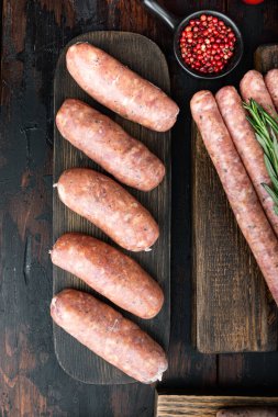 Çiğ organik domuz sosisi, üst manzara, eski siyah ahşap arka plan..