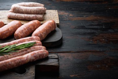 Domuz eti, sığır eti ve tavuk sosisi. Eski, siyah ahşap arka planda, yazı için yeri var..