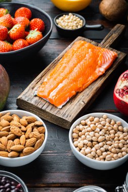 Sağlıklı dengeli diyet malzemeleri konsepti koyu ahşap arka planda.