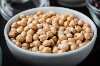 Siyah ahşap arka planda beyaz kasede nohut..