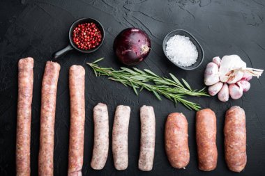 Çiğ sosis seti, üst görünüm, siyah arkaplan üzerinde.