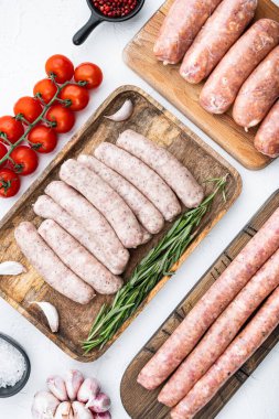 Çiğ sosis seti, beyaz arkaplanda üst görünüm.