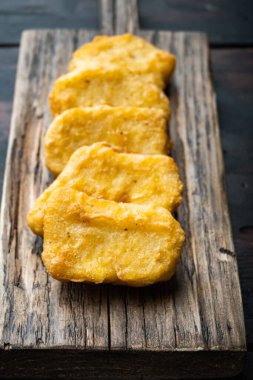 Koyu ahşap arka planda kızartılmış ev yapımı tavuk külçeleri..