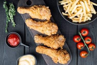 Kızarmış tavuk pirzolası siyah ahşap masada, üst tarafta..