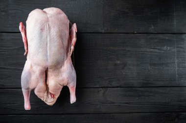 Çiğ yaban ördekleri siyah ahşap masa üzerinde, üst manzara, kopyalama alanı ile.