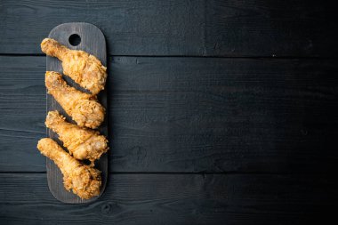 Tavuk budu siyah ahşap arka planda kızartılmış, düz uzanmış, metin için yeri var..