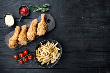 Kızarmış tavuk budu, siyah ahşap arka planda but parçaları, üst manzara, metin için yer var..